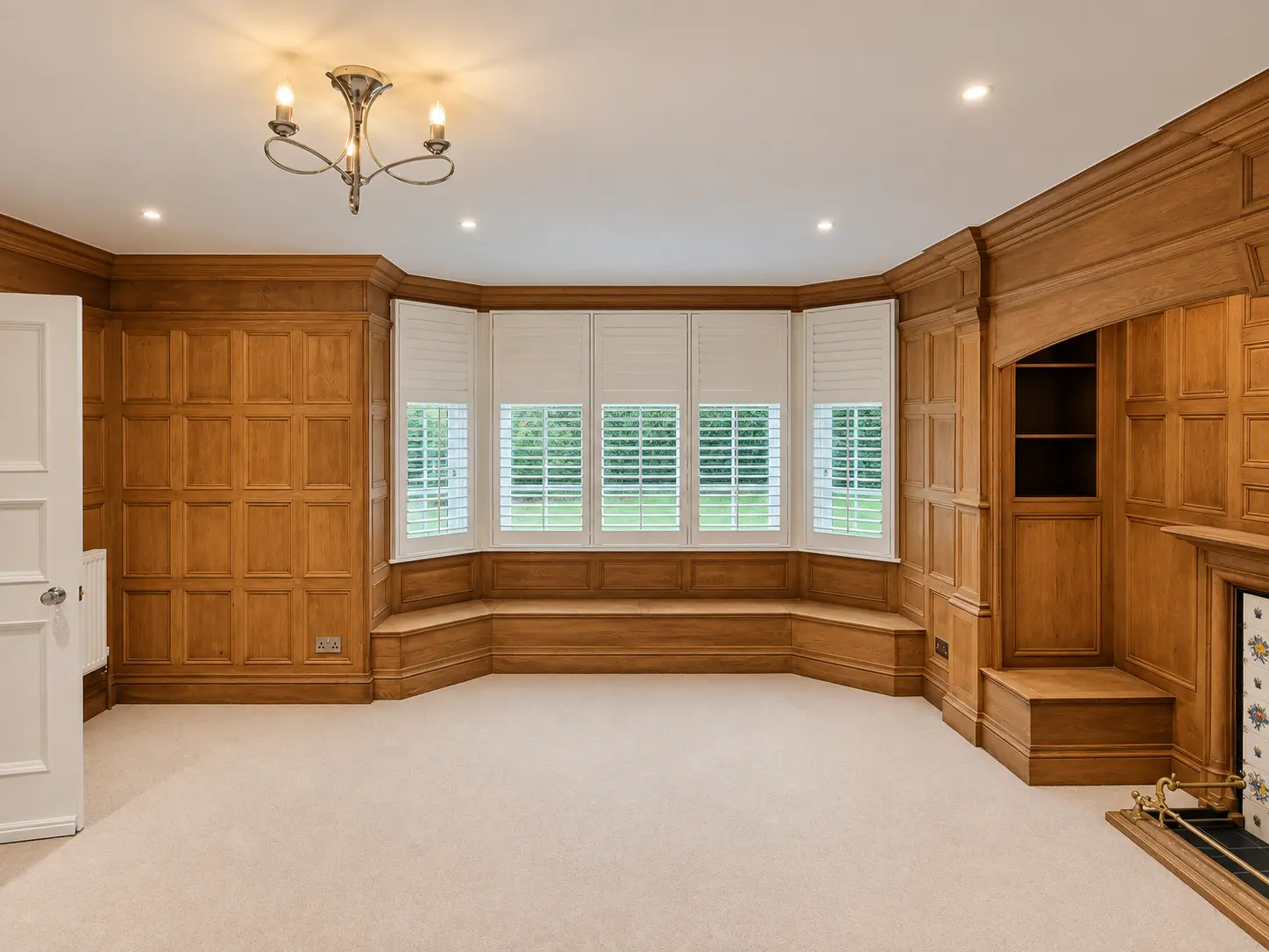 Full-height shutters in the wood-panelled dining-room bay window in the Esher display house.