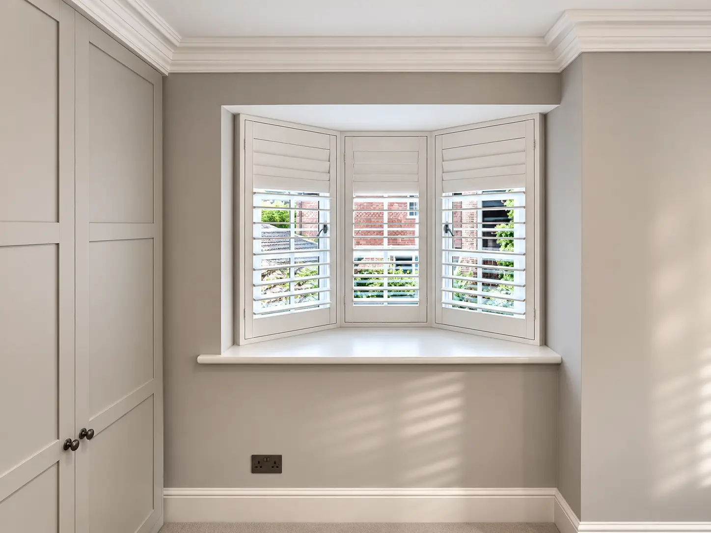 Full-height shutters following a hallway bay window in the Esher display house.