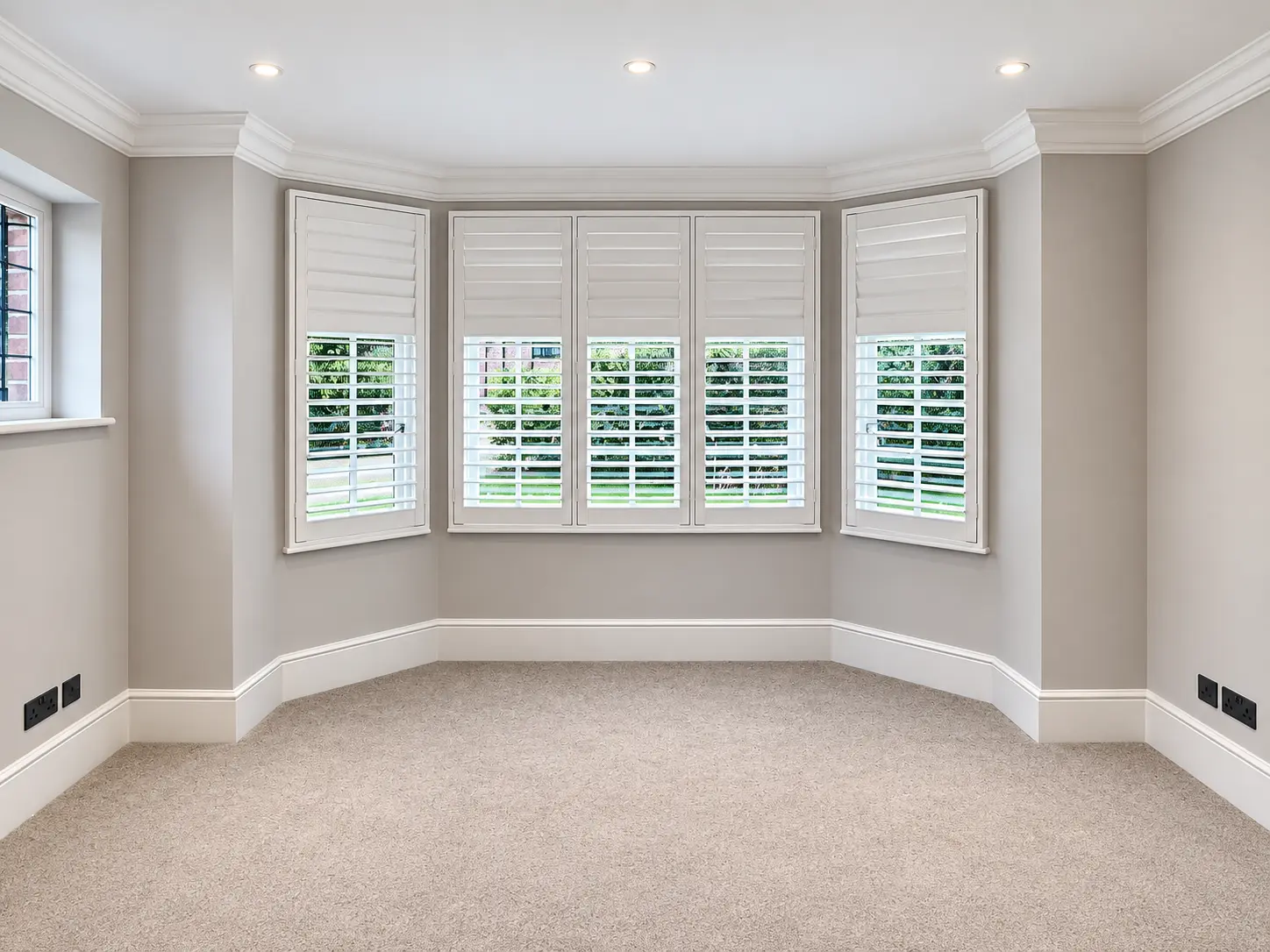 Full-height shutters following the living-room bay window in the Esher display house.