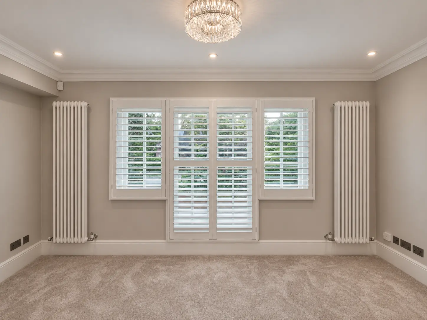 Full-height bedroom shutters across the window and central doors in the Esher display house.