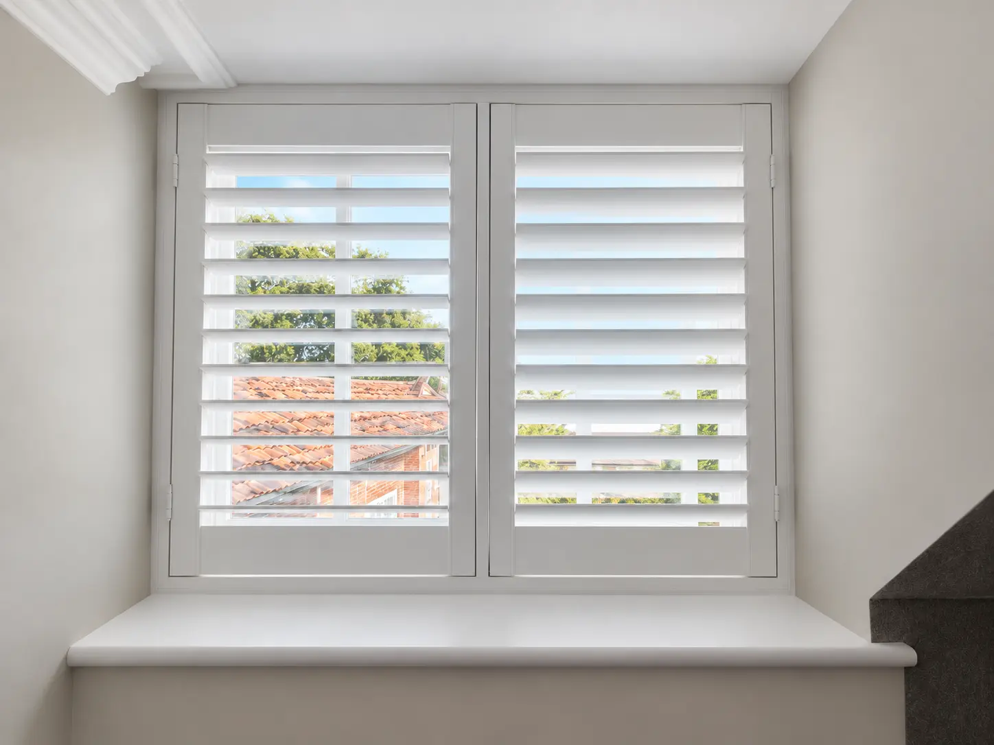 Full-height shutters at a hallway window in the Esher display house.