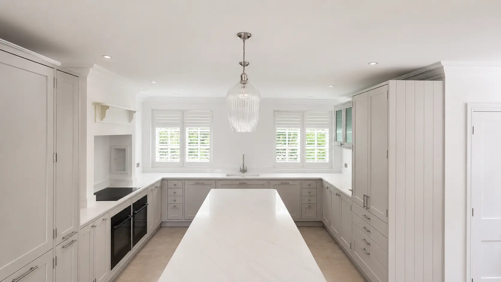 Full-height shutters at the two kitchen windows in the Esher display house.