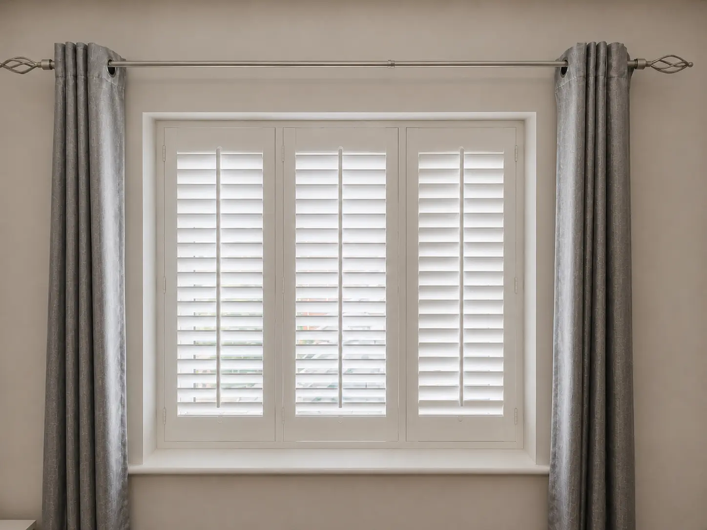 Three white full-height shutter panels at a dining-room window between grey curtains.